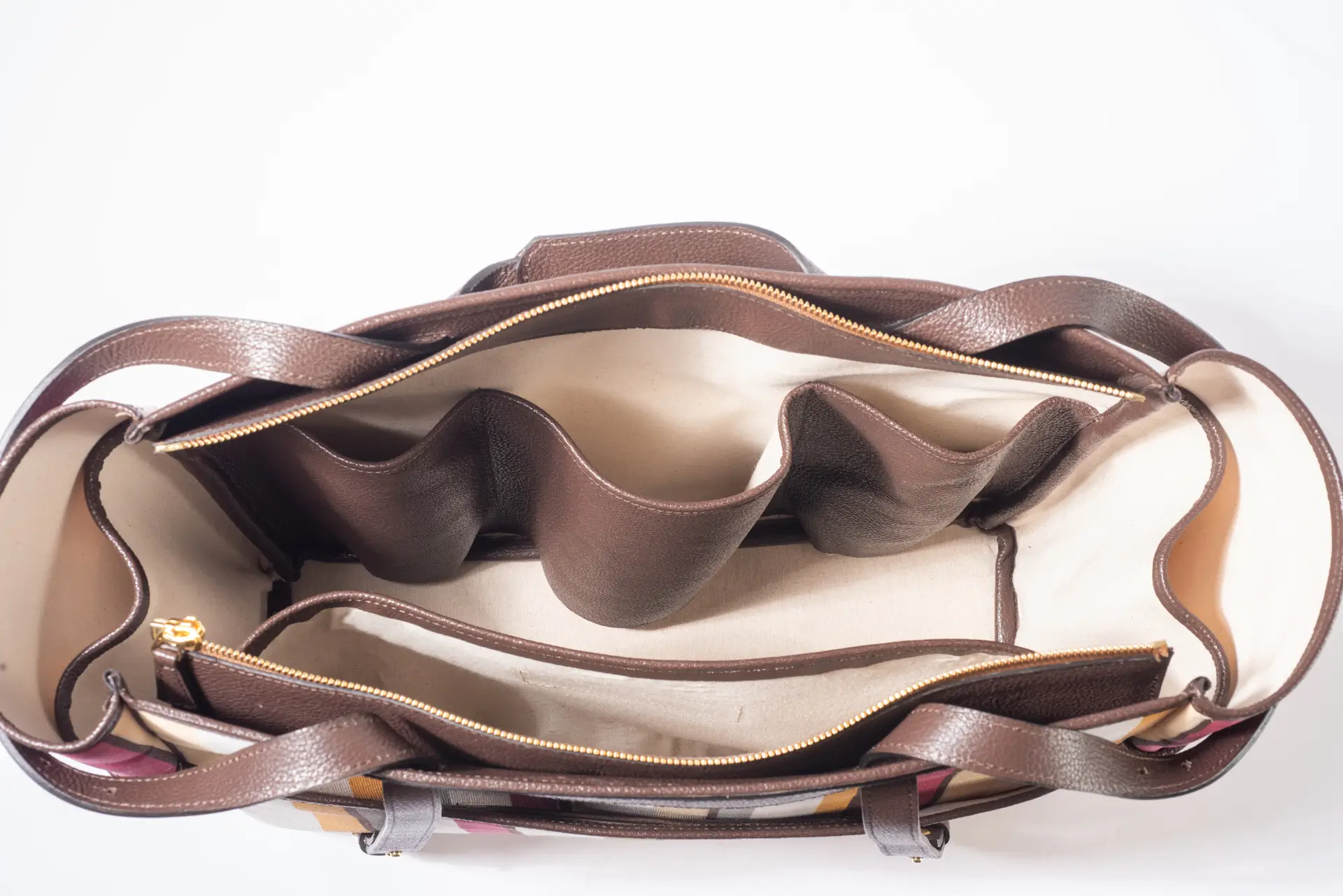 Vista dall'alto dell'interno della borsa Liber_TO di Lemanì, mostrando la capienza e la fodera chiara con scomparti e pochette interna in pelle marrone scuro. Questa borsa Lemanì Liber_TO multiriga offre un'organizzazione ottimale e un design unico per ogni occasione.